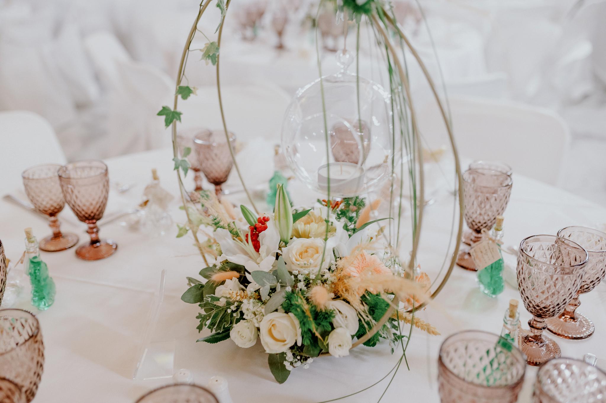 Κοντινή φωτογραφία στον στολισμό του γάμου ο οποίος αποτελείται από λευκά και σομόν τριαντάφυλλα και πρασινάδες.