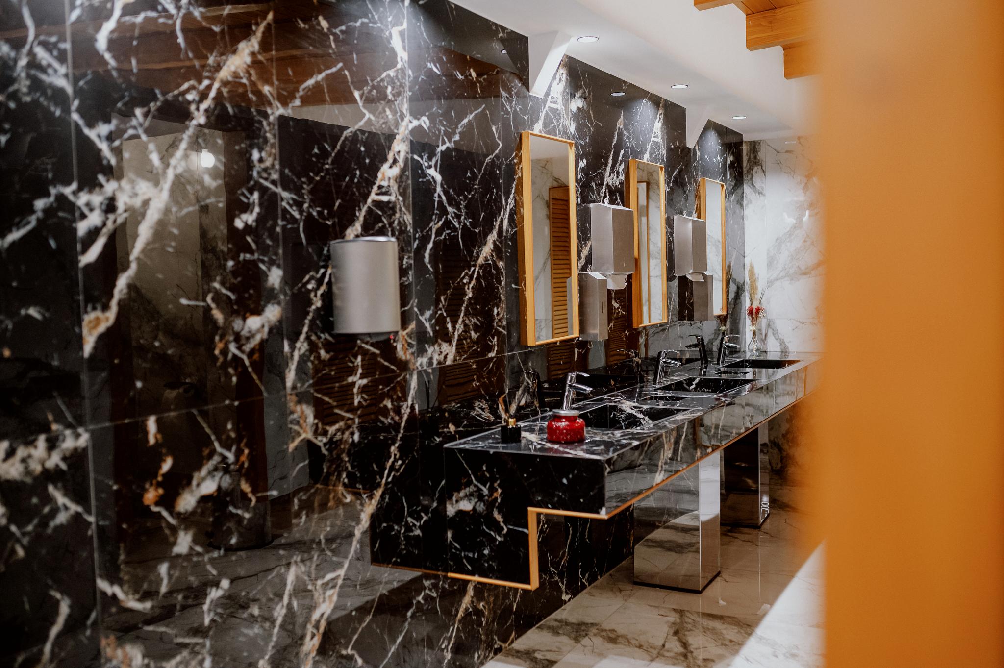 Φωτογραφία από τα μπάνια και τους νιπτήρες που είναι μαύρο μάρμαρο γρανιτοπλακάκι επάνω από κάθε νιπτήρα έχει καθρέπτη