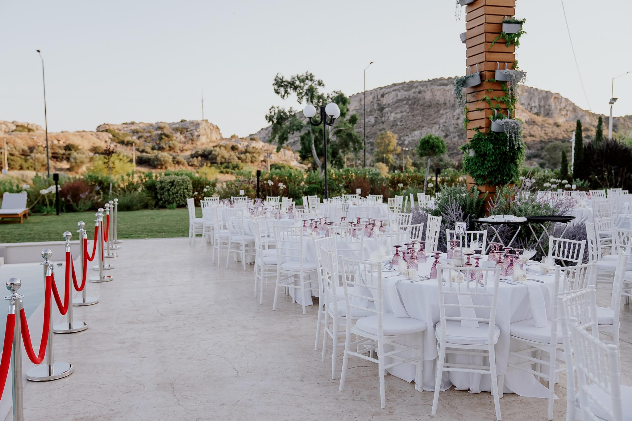 Κοντινή φωτογραφία στις ροτόντες . Περιμετρικά είναι τοποθετημένες καρέκλες tiffany . Τα τραπέζια είναι στρωμένα.