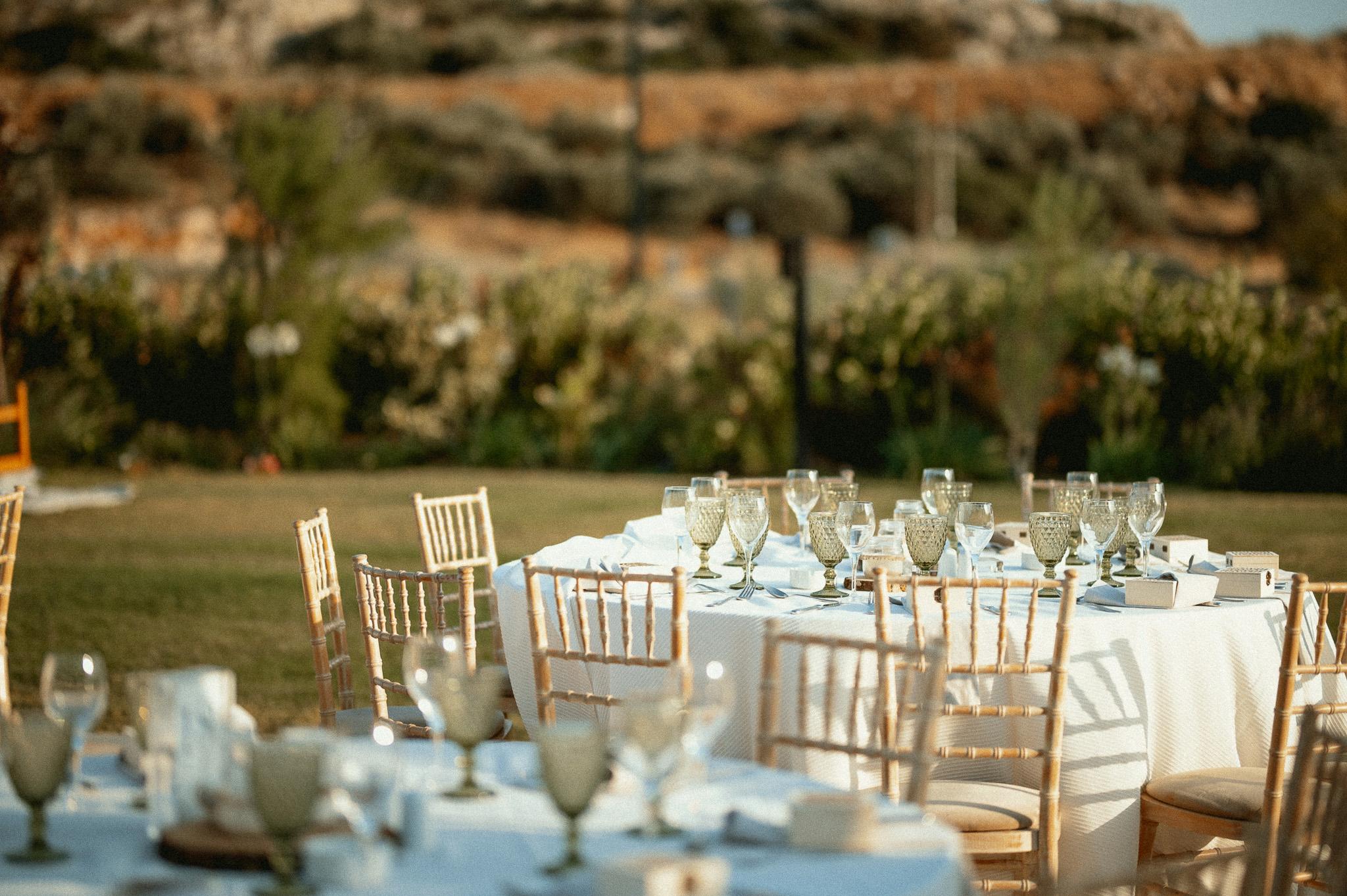 Φωτογραφία που έχει στήσει τα τραπέζια το catering . Περιμετρικά από τις ροτόντες είναι οι tiffany καρέκλες. Στο βάθος υπάρχει γκαζόν όπως επίσης και ο κήπος με τα φυτά που υπάρχει στο κτήμα μας.