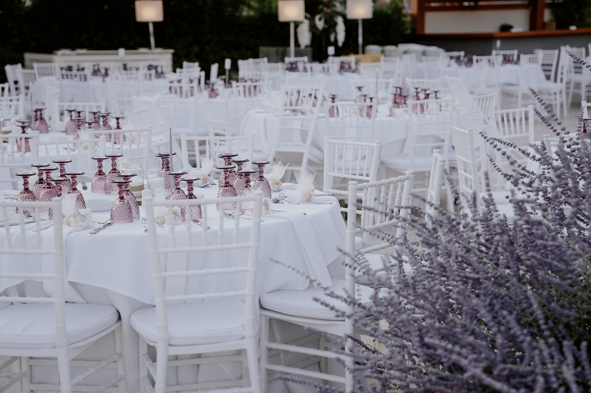 Κοντινή φωτογραφία στις ροτόντες . Περιμετρικά είναι τοποθετημένες καρέκλες tiffany . Τα τραπέζια είναι στρωμένα.