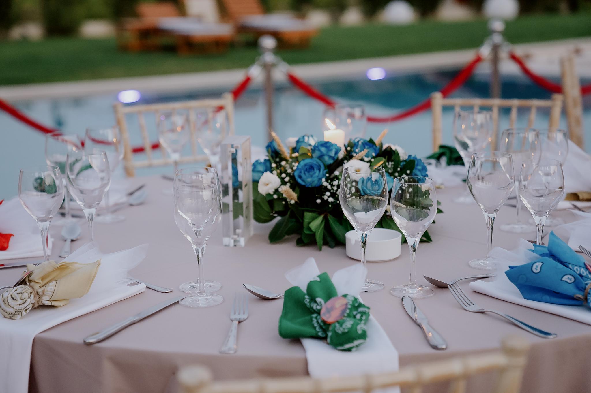 Κοντινό πλάνο στα λουλούδια που βρίσκονται επάνω στα τραπέζια τα οποία περιέχουν μπλε τριαντάφυλλα και λευκά . Κοντινή φωτογραφία σε σε μπομπονιέρες.