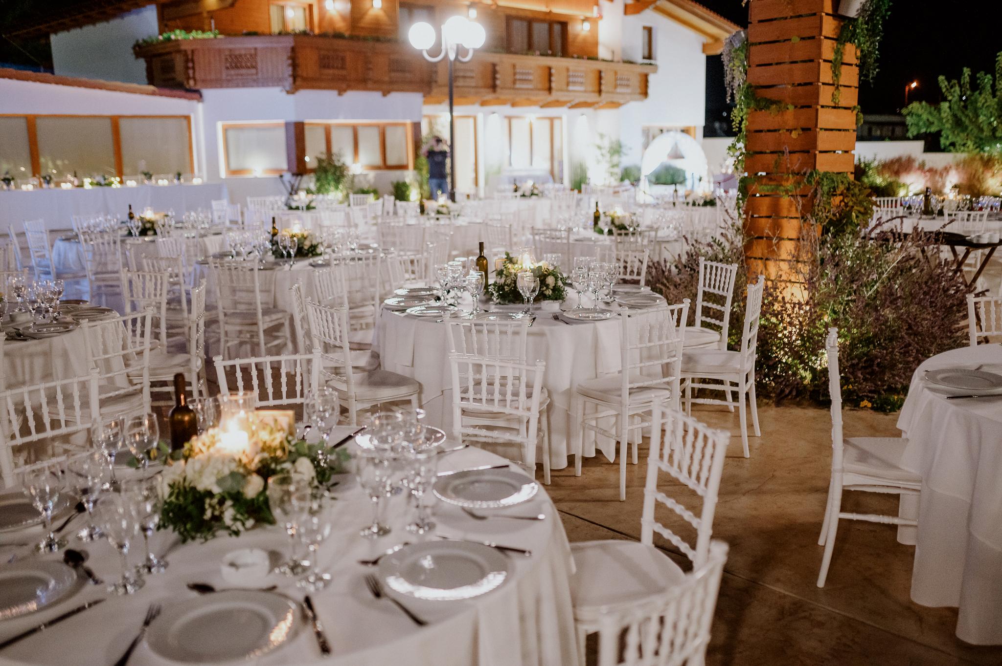 Με φόντο το ελβετικό σαλέ και το ξύλο φαίνονται τα τραπέζια του catering στρωμένα με μαχαιροπίρουνα και ποτήρια έτοιμα να υποδεχτούν τους καλεσμένους που θα έρθουν από την εκκλησία.