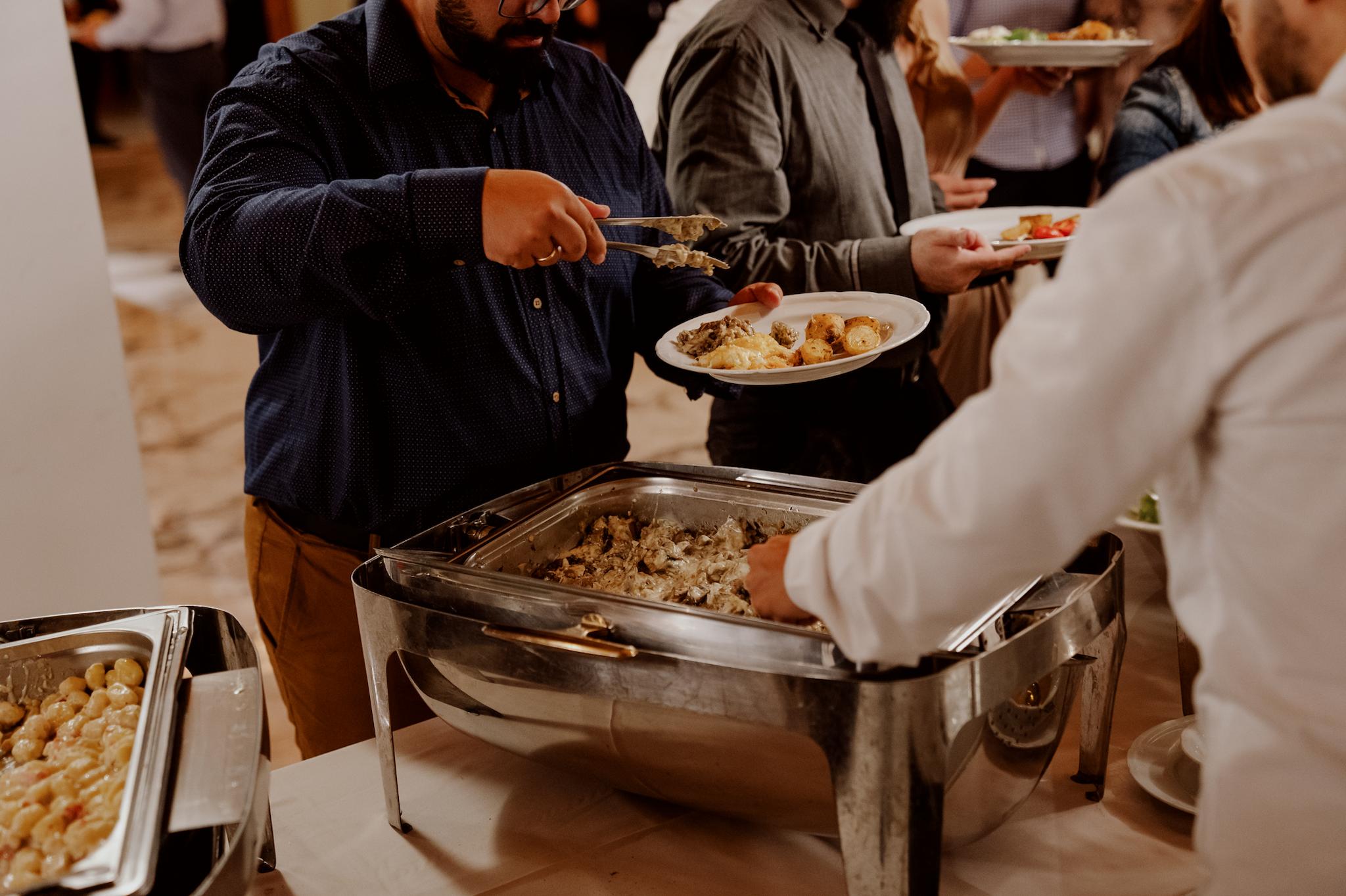 Κοντινή φωτογραφία από τον κόσμο που σερβίρετε στον μπουφέ του catering