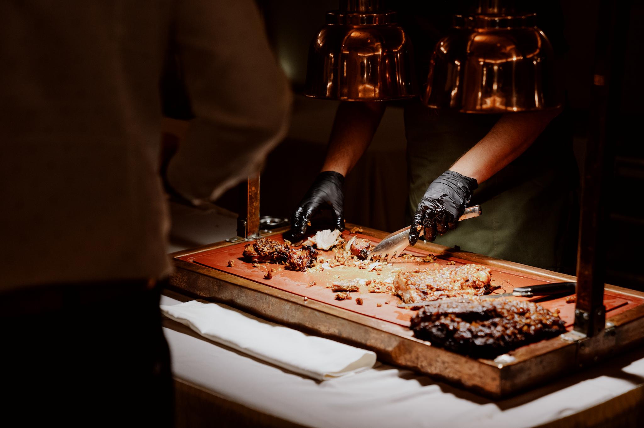 Κοντινή φωτογραφία από άνθρωπο του catireing για το πως κάνει την κοπή του κρέατος